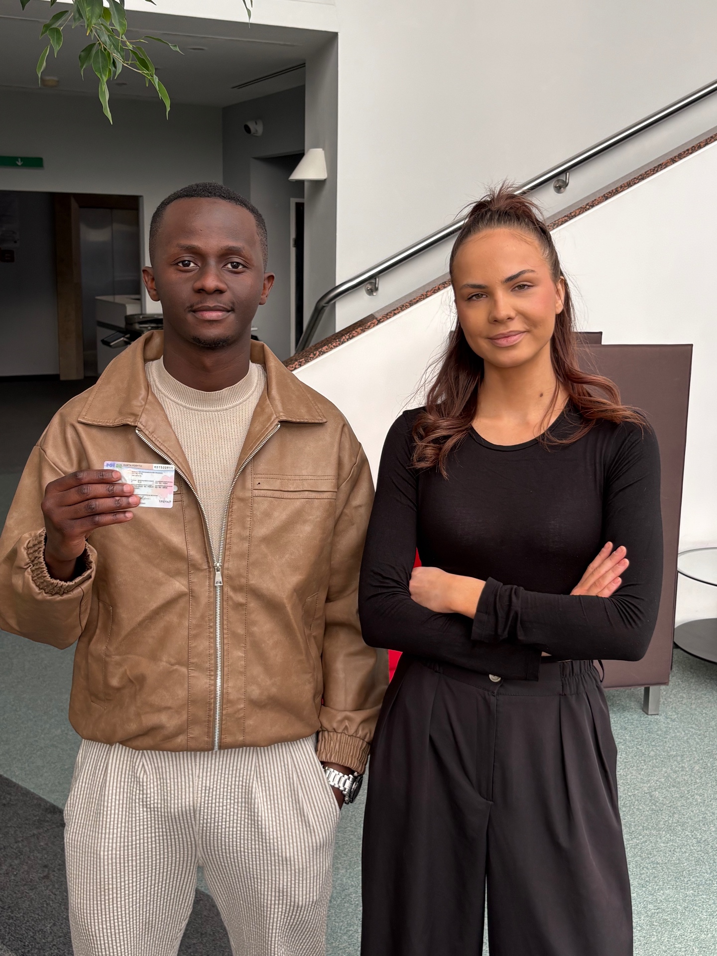 Diverse group of happy New Chapter Law clients holding up their Polish temporary residence cards