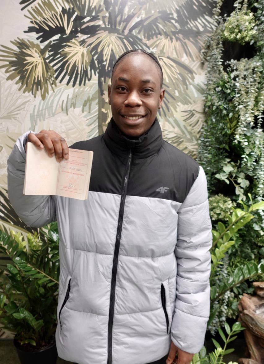 Young client from Africa smiling with his stamped Polish passport